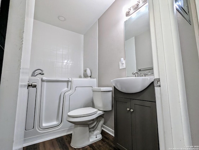 bathroom featuring toilet, vanity, and hardwood / wood-style floors