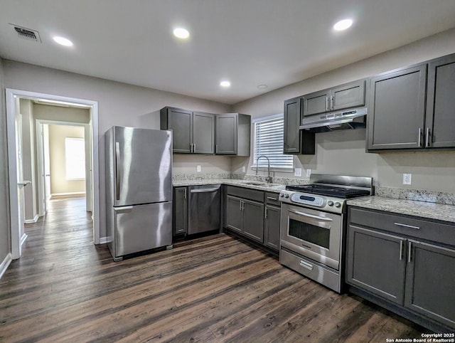 kitchen featuring light stone countertops, stainless steel appliances, dark hardwood / wood-style flooring, and sink