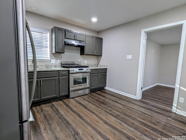 kitchen with dark wood-type flooring, stainless steel appliances, gray cabinetry, and light stone countertops