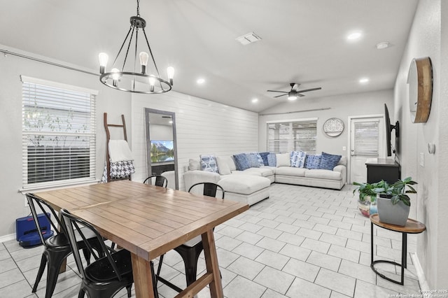 dining area featuring vaulted ceiling, light tile patterned floors, and ceiling fan with notable chandelier