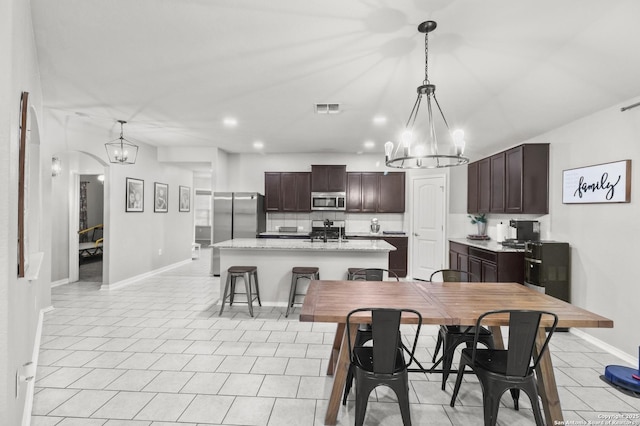 dining space with light tile patterned floors and a chandelier