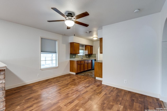 kitchen with ceiling fan, dark hardwood / wood-style floors, dishwasher, decorative backsplash, and sink