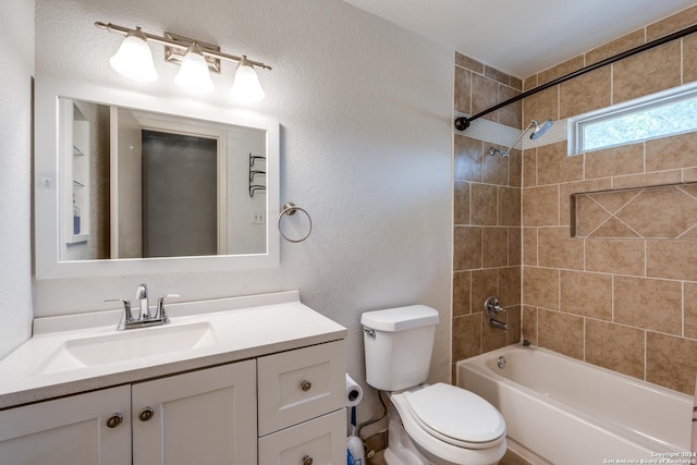 full bathroom with toilet, vanity, and tiled shower / bath