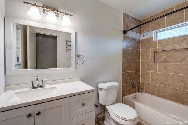 full bathroom featuring toilet, tiled shower / bath, and vanity