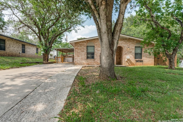 ranch-style house featuring a front lawn and a carport