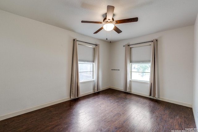 spare room featuring dark wood-type flooring and ceiling fan