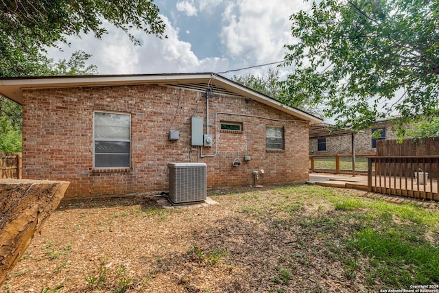 rear view of house with a wooden deck and central AC