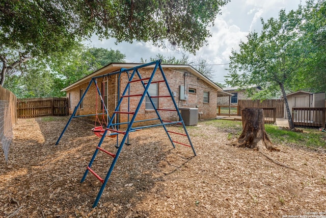 view of jungle gym with central AC and a storage unit