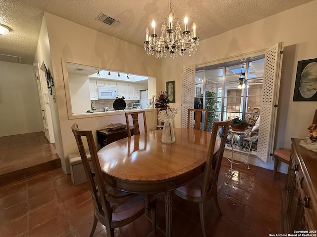 tiled dining space featuring a textured ceiling and a notable chandelier