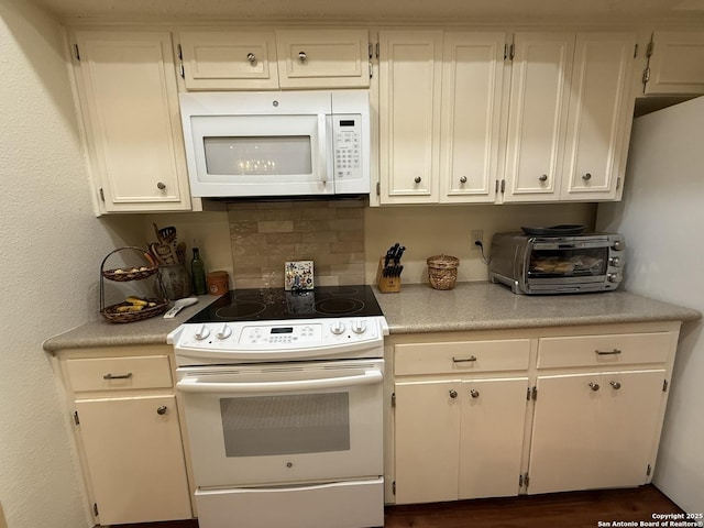 kitchen with white cabinetry, decorative backsplash, and white appliances