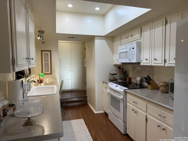 kitchen with white cabinetry, dark hardwood / wood-style floors, backsplash, white appliances, and sink