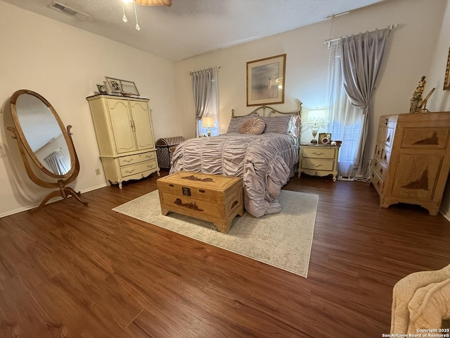 bedroom featuring a textured ceiling and dark hardwood / wood-style flooring