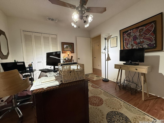 home office with ceiling fan and dark wood-type flooring