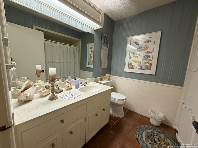 bathroom with toilet, vanity, tile patterned floors, and a textured ceiling