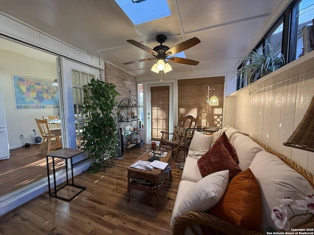 living room featuring ceiling fan, a skylight, and dark hardwood / wood-style flooring