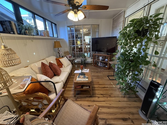 living room with wood-type flooring and ceiling fan with notable chandelier