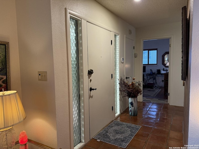 tiled foyer featuring a textured ceiling