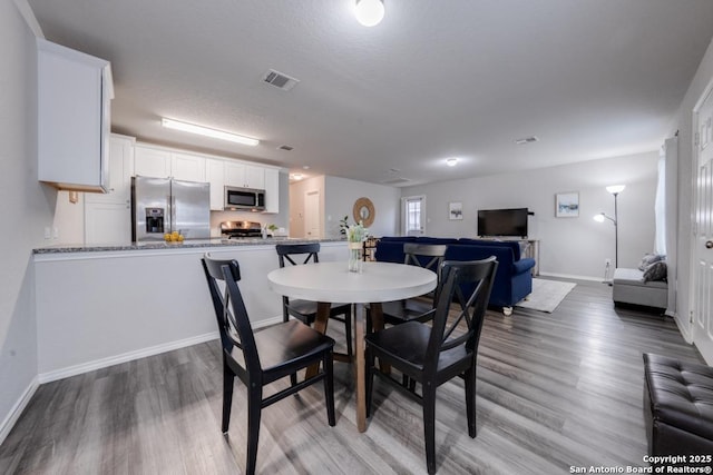 dining room with a textured ceiling and hardwood / wood-style flooring