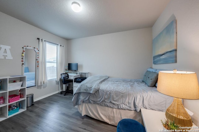 bedroom featuring a textured ceiling and dark hardwood / wood-style flooring