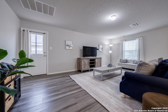 living room featuring a textured ceiling and dark wood-type flooring