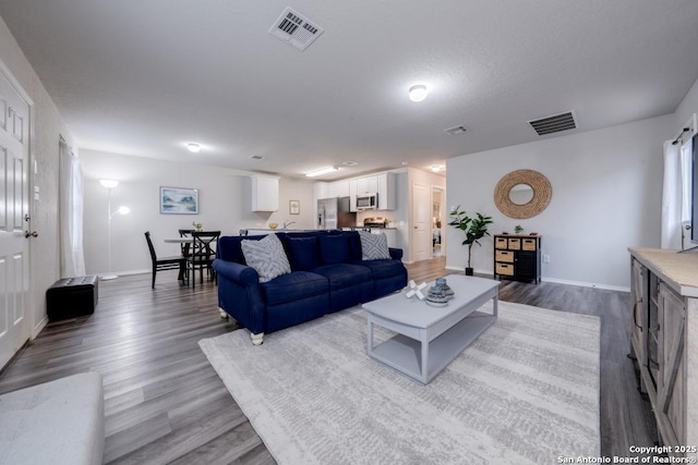 living room featuring a textured ceiling and hardwood / wood-style flooring