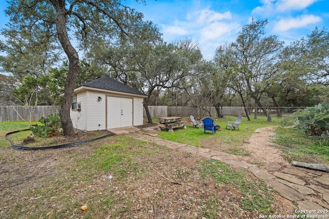 view of yard featuring cooling unit, a storage shed, and a fire pit