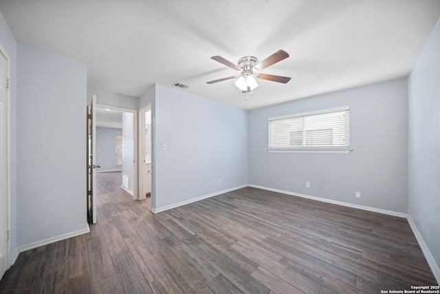 empty room with ceiling fan and dark hardwood / wood-style flooring