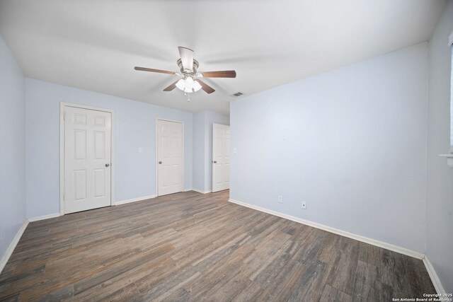 unfurnished room featuring dark wood-type flooring and ceiling fan