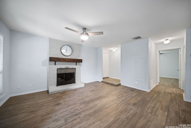 unfurnished living room with ceiling fan, dark wood-type flooring, and a fireplace