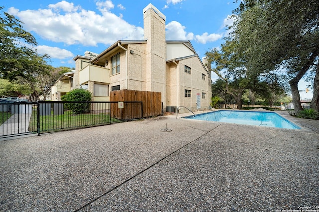 view of pool with cooling unit and a patio