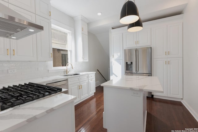 kitchen featuring a center island, exhaust hood, decorative light fixtures, white cabinetry, and light stone counters