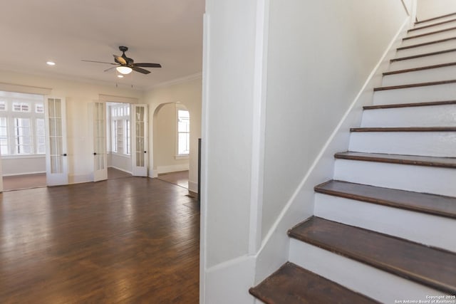 staircase with ceiling fan, ornamental molding, and hardwood / wood-style floors