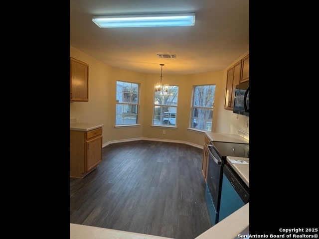 kitchen with dark hardwood / wood-style flooring, range, pendant lighting, and a notable chandelier