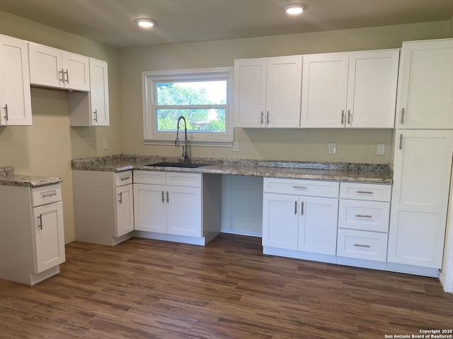 kitchen featuring light stone counters, sink, white cabinetry, and dark hardwood / wood-style floors