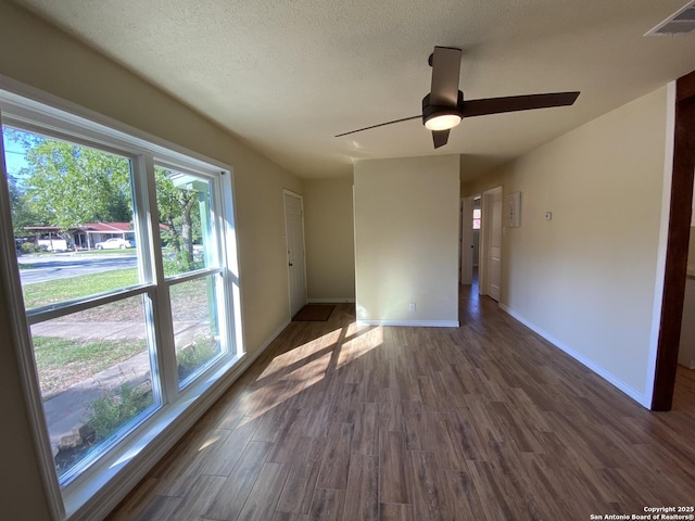 empty room with ceiling fan and dark hardwood / wood-style flooring