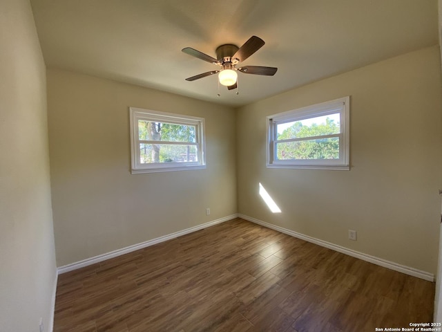 spare room with ceiling fan, plenty of natural light, and dark hardwood / wood-style flooring