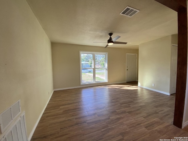 empty room featuring a textured ceiling, dark wood-type flooring, and ceiling fan