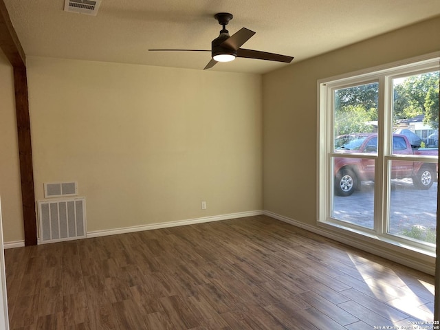 spare room with ceiling fan, dark hardwood / wood-style flooring, and plenty of natural light