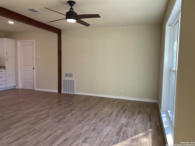 unfurnished room with hardwood / wood-style flooring, ceiling fan, and beamed ceiling