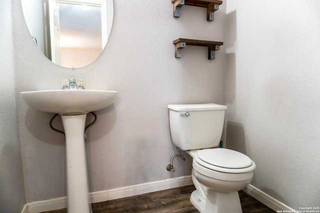 bathroom with toilet and hardwood / wood-style floors