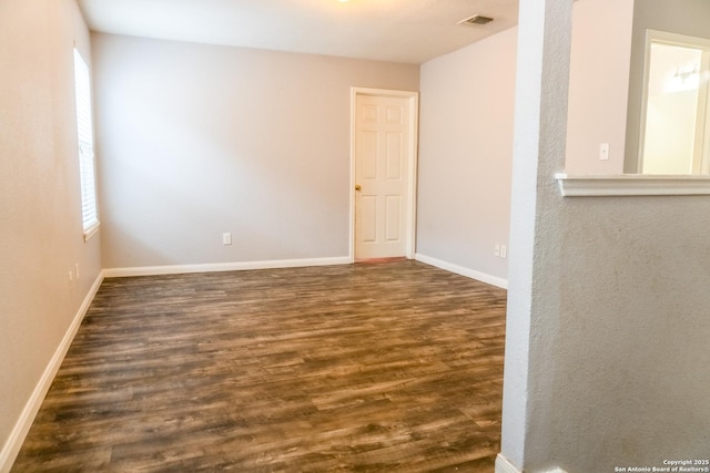 empty room with dark hardwood / wood-style flooring