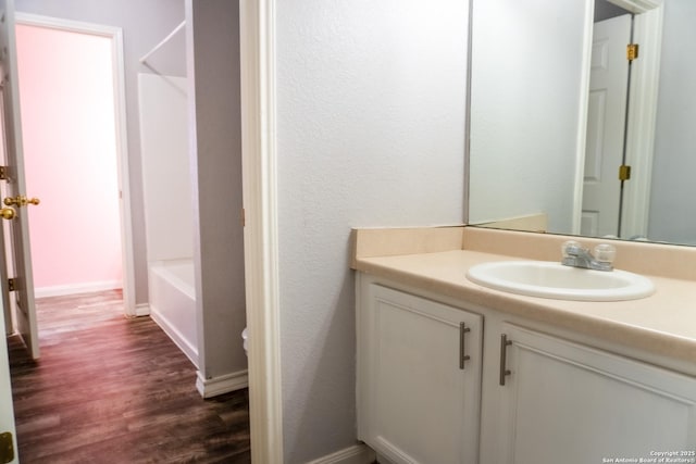 bathroom featuring wood-type flooring, shower / tub combination, and vanity