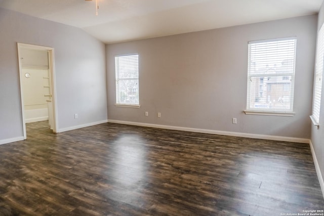 unfurnished room featuring vaulted ceiling and dark hardwood / wood-style floors