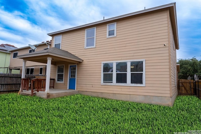 back of property featuring a patio area and a lawn