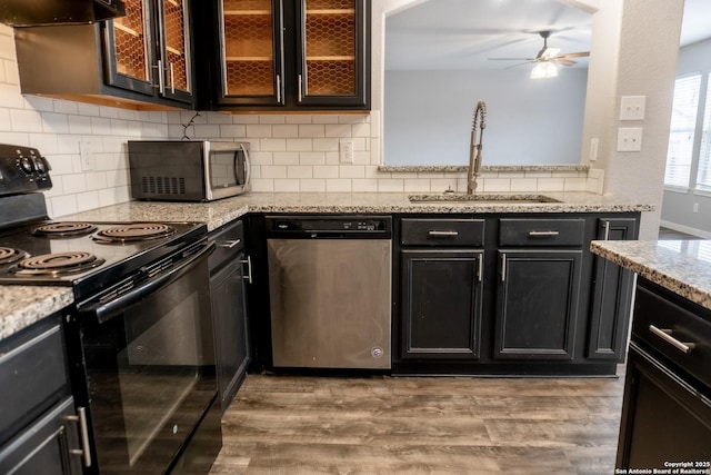 kitchen with light hardwood / wood-style floors, extractor fan, ceiling fan, stainless steel appliances, and sink