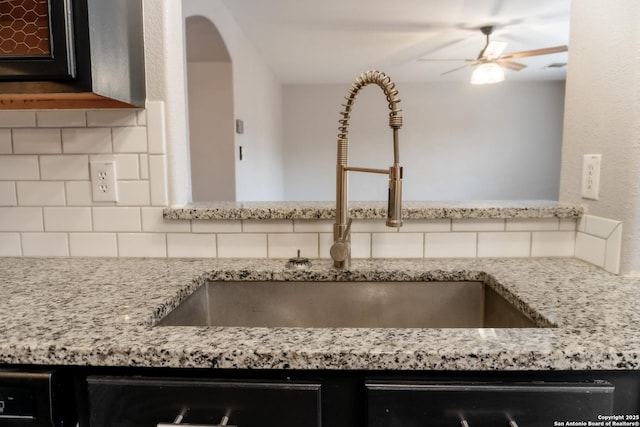 kitchen with dishwasher, ceiling fan, sink, backsplash, and light stone counters