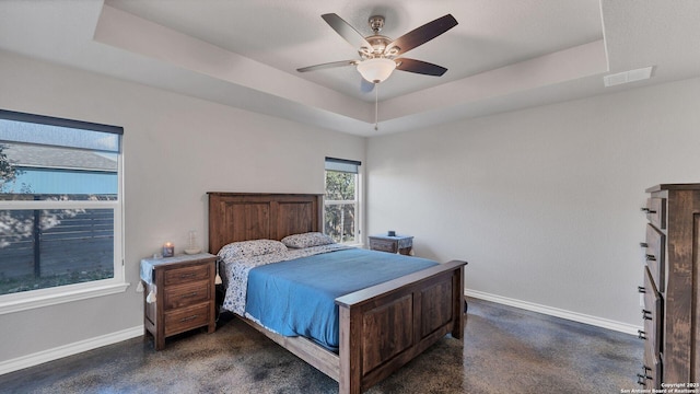 bedroom featuring ceiling fan and a raised ceiling