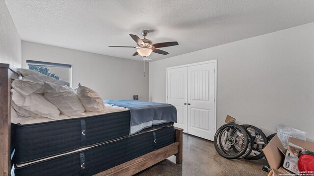 bedroom featuring ceiling fan, a textured ceiling, and a closet