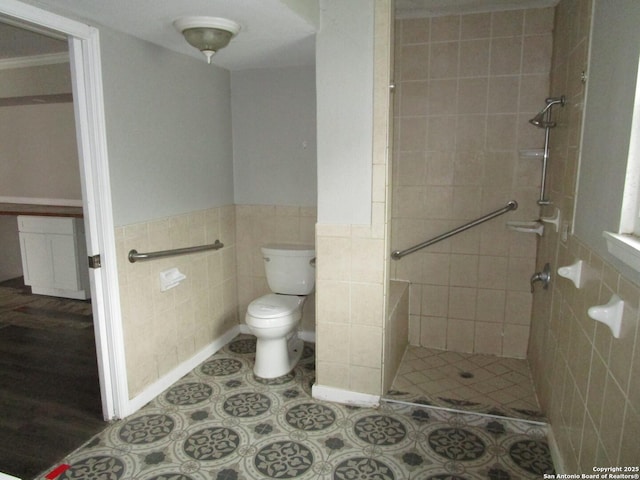 bathroom with toilet, tile walls, and a tile shower