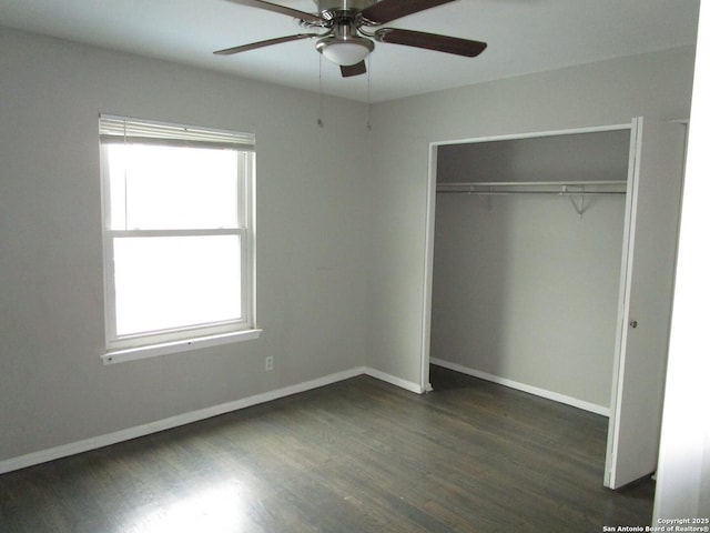 unfurnished bedroom with ceiling fan, a closet, and dark wood-type flooring